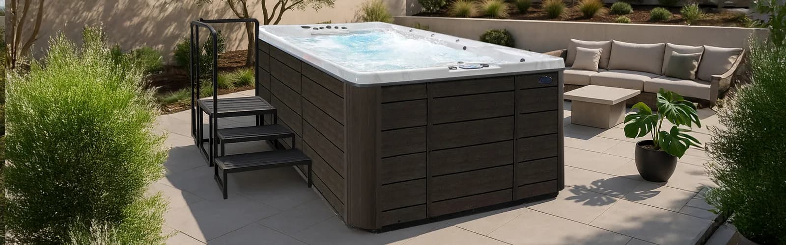 Cal Spas Swim Pro swim spa with a dark cabinet and entry steps on a stone patio